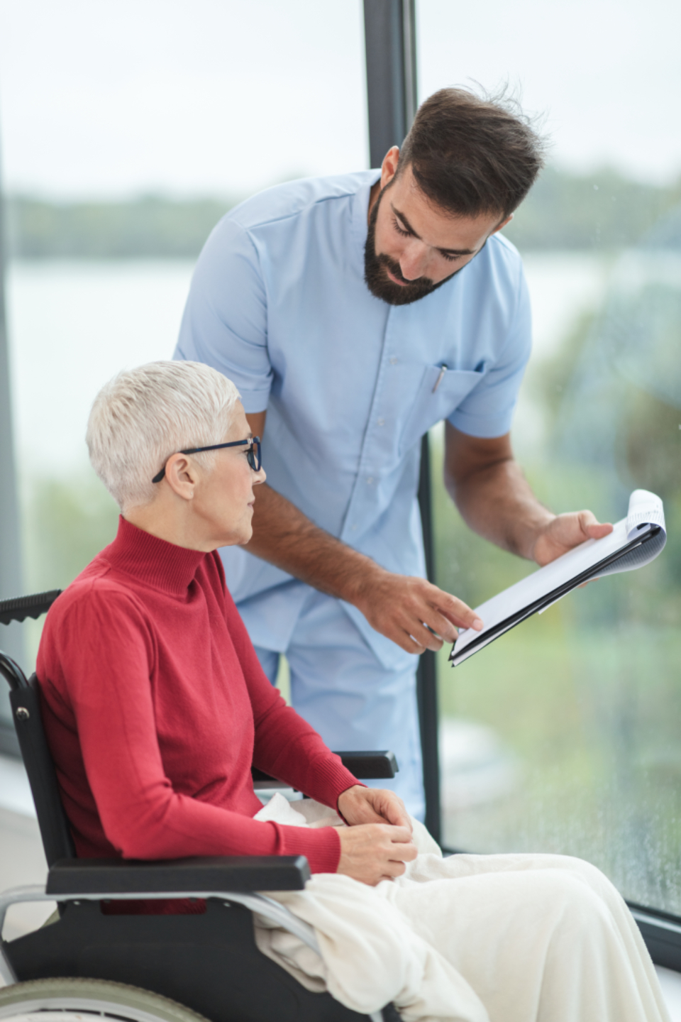 A caregiver reviewing a personalized care plan with a client who uses a wheelchair